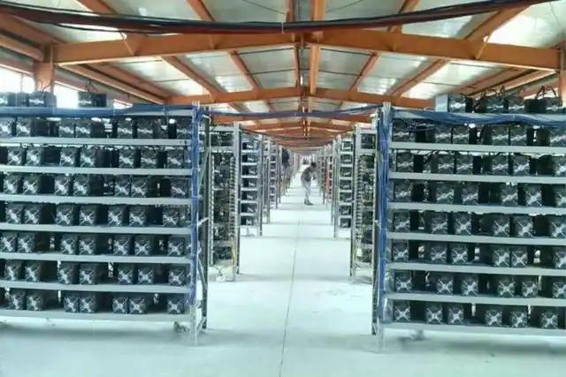 A large mining farm with rows of active mining rigs